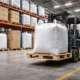 Forklift lifting bulk container on a CP9 pallet inside an industrial warehouse