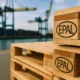 EPAL pallets for European exports stacked at a port with cranes in the background.