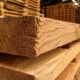 Close-up of dense hardwood timber boards stacked in a pallet manufacturing yard showing tight wood grain