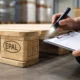 Inspector checking EPAL stamp to show how to spot fake EPAL pallets in a warehouse