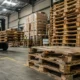 Repairing vs replacing wooden pallets in an industrial warehouse with forklift handling wooden pallets and damaged pallet stacks.