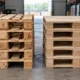 Solid wood pallets next to plywood pallets showing material comparison